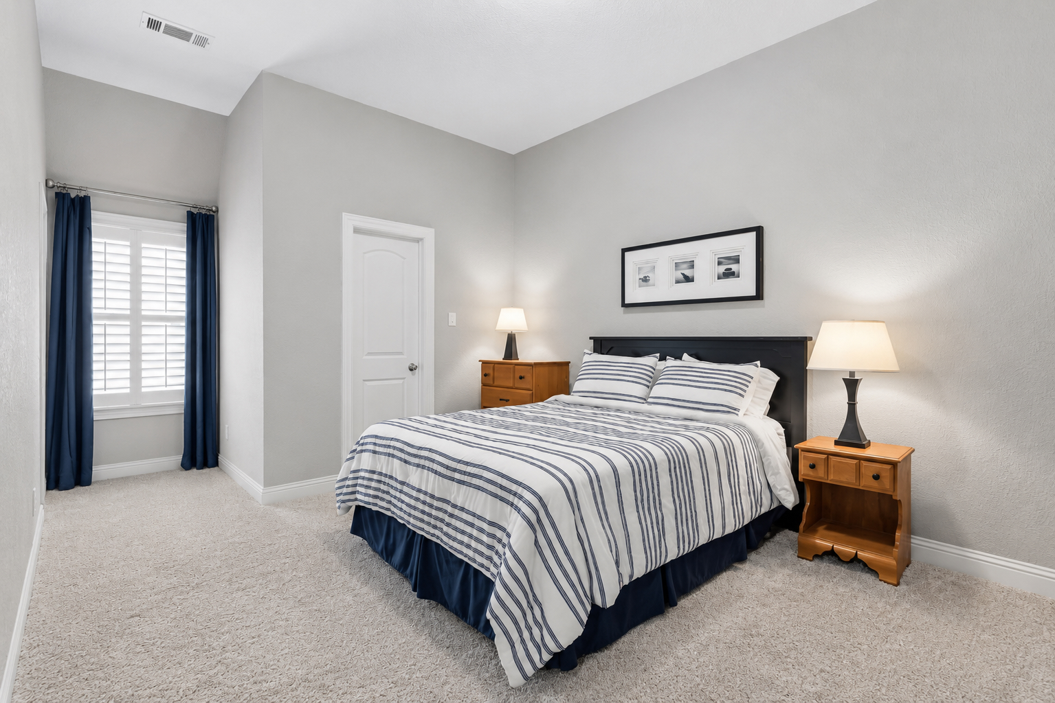 Upstairs bedroom with queen bed, walk-in closet, and plantation shutters
